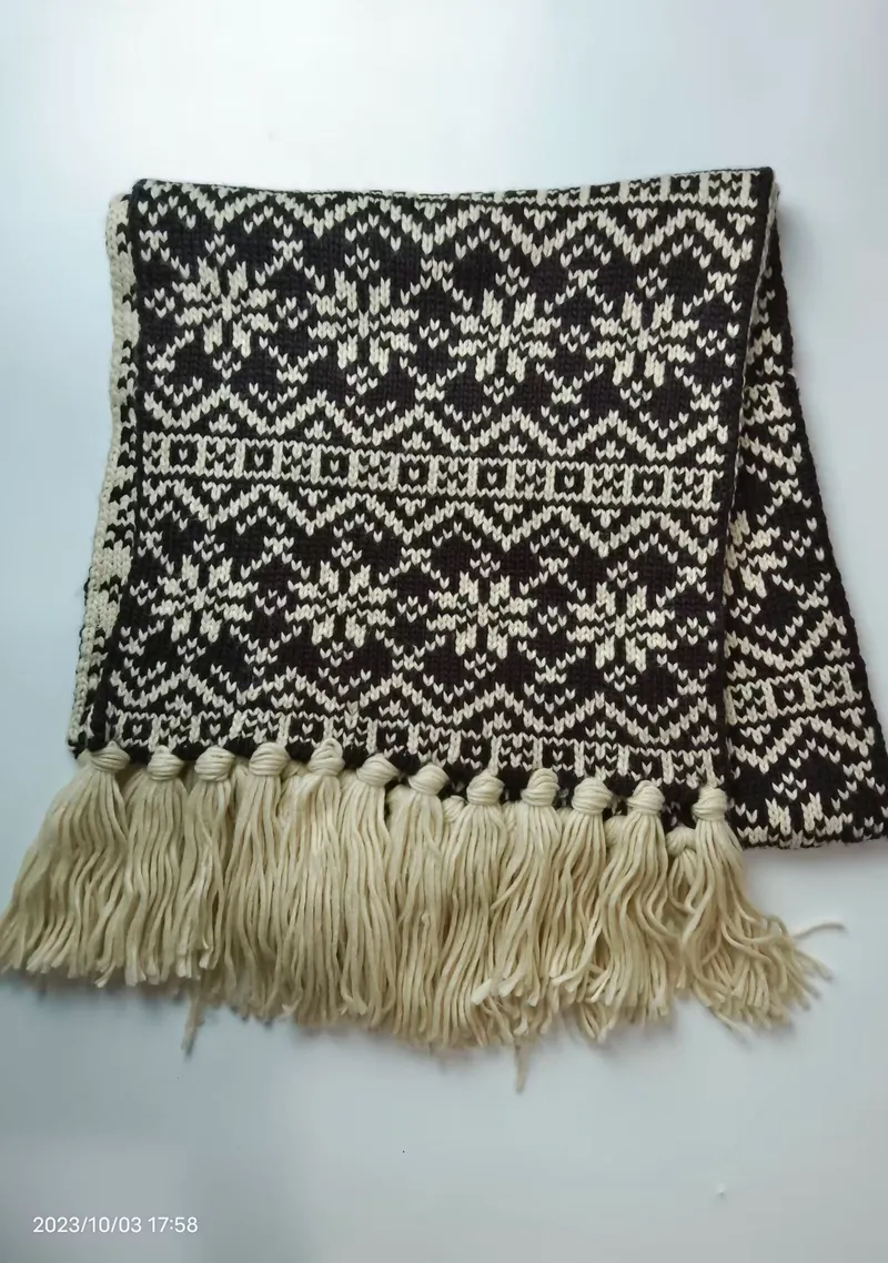 Gefalteter Winterschal in Schwarz und Creme aus Strick mit nordischem Schneeflocken-Jacquardmuster und langen Quasten an den Enden