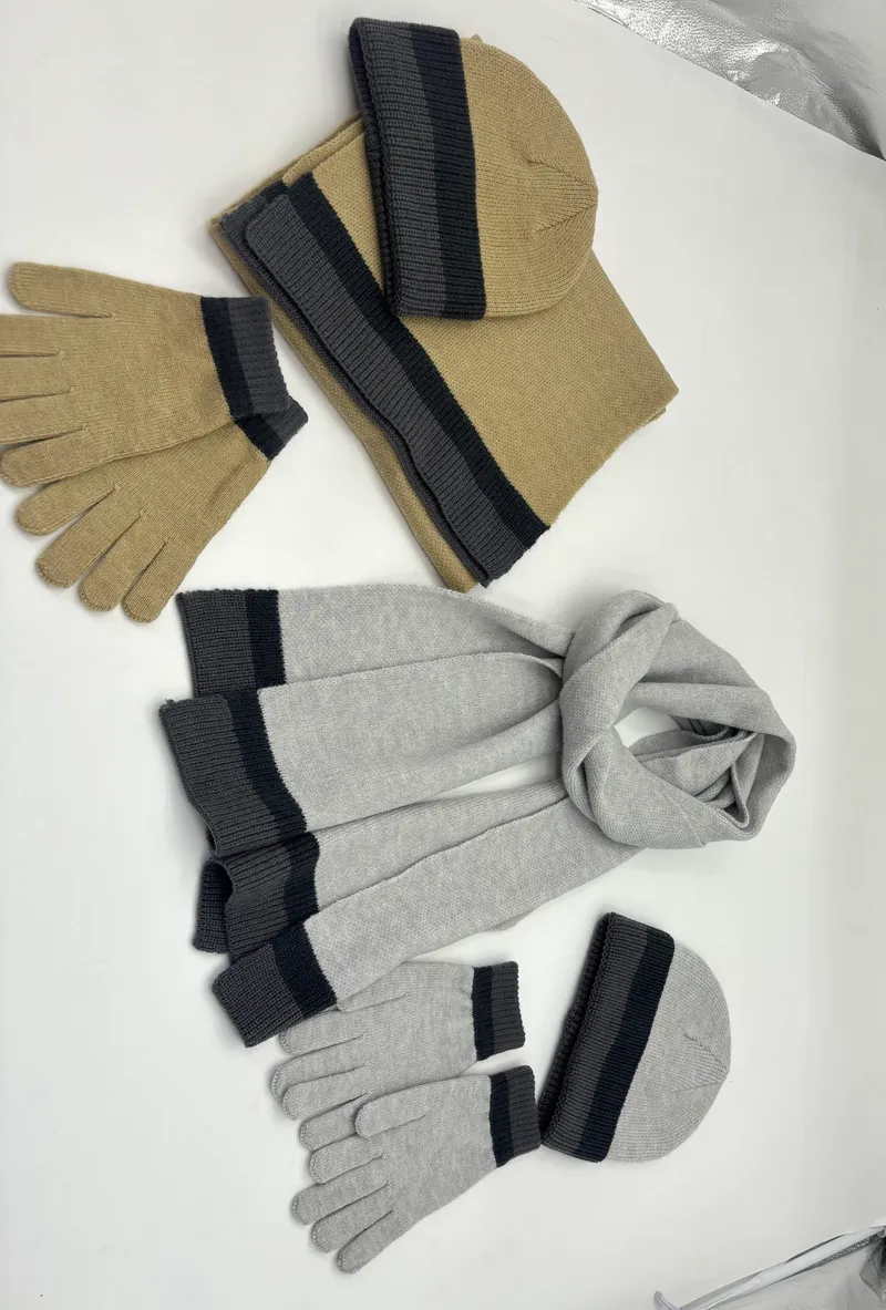 Zwei dreiteilige Strick-Wintersets mit Mütze, Schal und Fäustlingen in Sandbeige und Hellgrau mit dunkleren Streifen, nebeneinander arrangiert