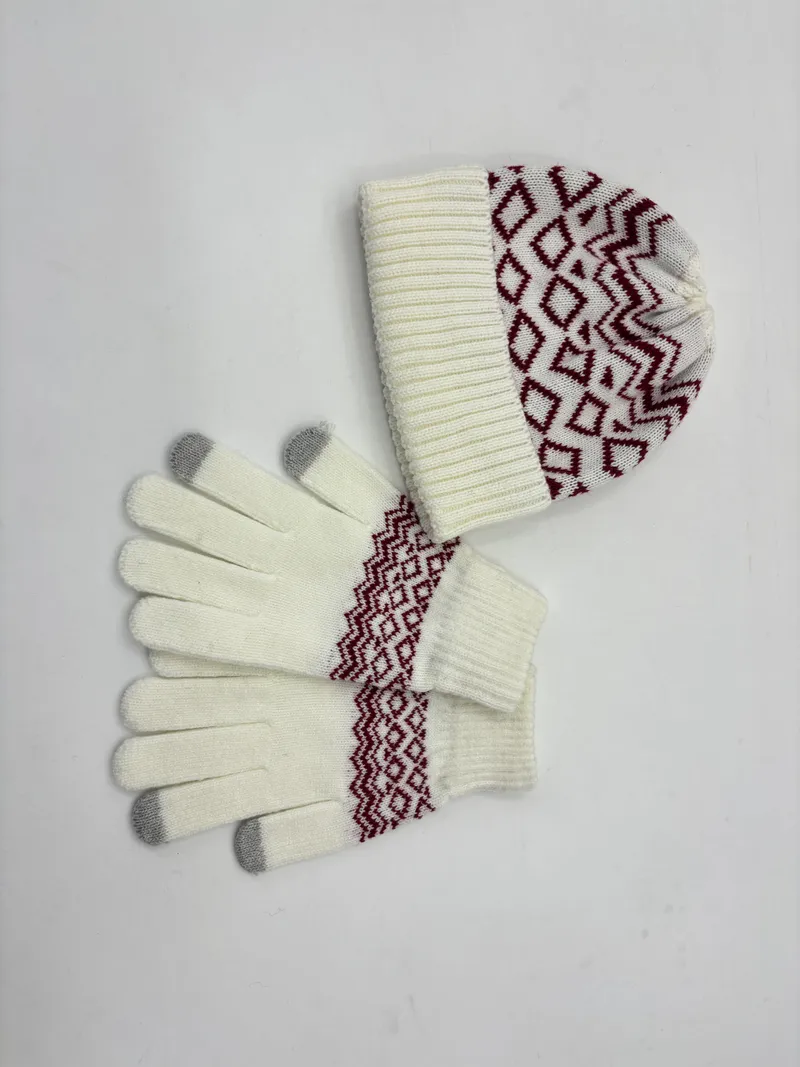 Cremeweiße Strickmütze und dazu passende Touchscreen-Handschuhe mit burgunderrotem geometrischem Fair-Isle-Muster, auf weißem Hintergrund