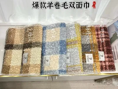 Fünf lockig strukturierte Bouclé-Waschlappen im Karomuster, nebeneinander in Beige, Blau, Gelb, Braun und Burgunderrot fotografiert