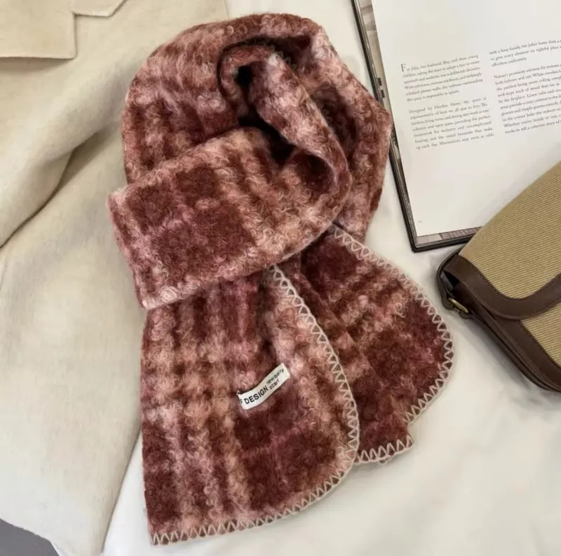 Weicher Mohair-Schal mit Karomuster in Rosé und Burgund, mit cremefarbener Sticknaht am Rand, zusammen mit Buch und Handtasche in Szene gesetzt