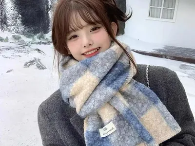 Oversized Winterschal in Blau und Creme mit Karomuster und Fransenabschluss, in verschneiter Außenumgebung getragen