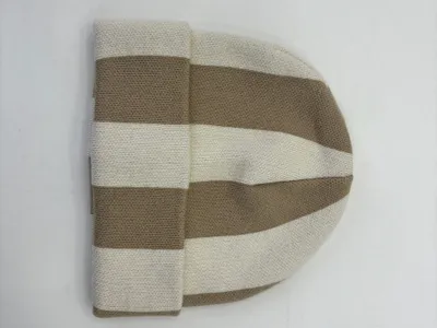 Flachliegende Strickmütze mit breiten senkrechten Streifen in Beige und Naturweiß mit Umschlagrand, auf weißem Untergrund