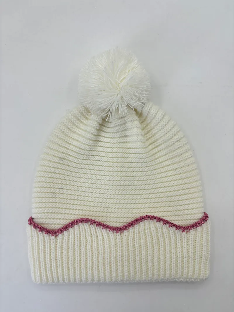 Cremefarben grob gestrickte Wintermütze mit fluffigem Bommel oben und dekorativer rosa Zickzack-Stickerei am Rand