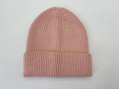 Altrosa Rippstrickmütze mit gefaltetem Bund, flach auf weißem Hintergrund liegend, zarte Feinstrick-Wintermütze