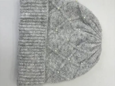 Weiche graue Strickmütze mit Rautenmuster und vereinzelten Perlen-Akzenten, auf weißem Hintergrund flachliegend