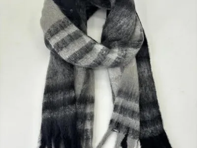 Weich gebürsteter Winterschal mit schwarz-grauen Querstreifen, langem Fransenbesatz und Schlaufenknoten, liegend auf weißem Untergrund