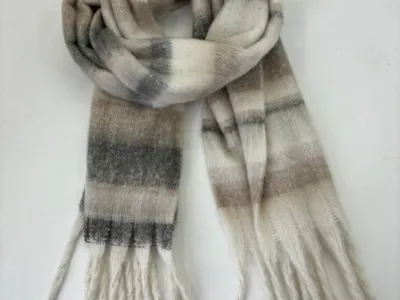 Gebürsteter Winterschal in Creme und Grau mit Karomuster und weißen Fransenden, locker gewickelt vor weißem Hintergrund