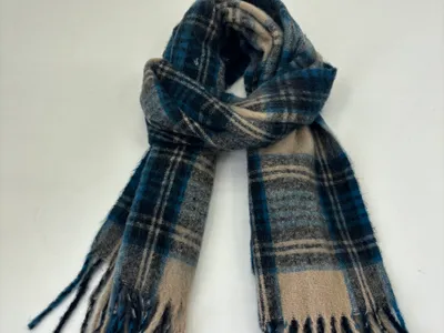 Weicher Tartanschal in Blau, Beige und Grau mit schottischem Karimuster und Fransenden, locker gewickelt auf weißem Hintergrund