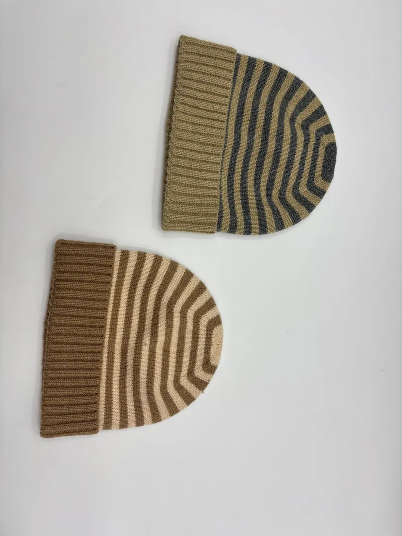 Zwei gestreifte Strickmützen mit Rippenbündchen in den Farbvarianten Khaki-Grau und Camel-Creme auf weißem Untergrund