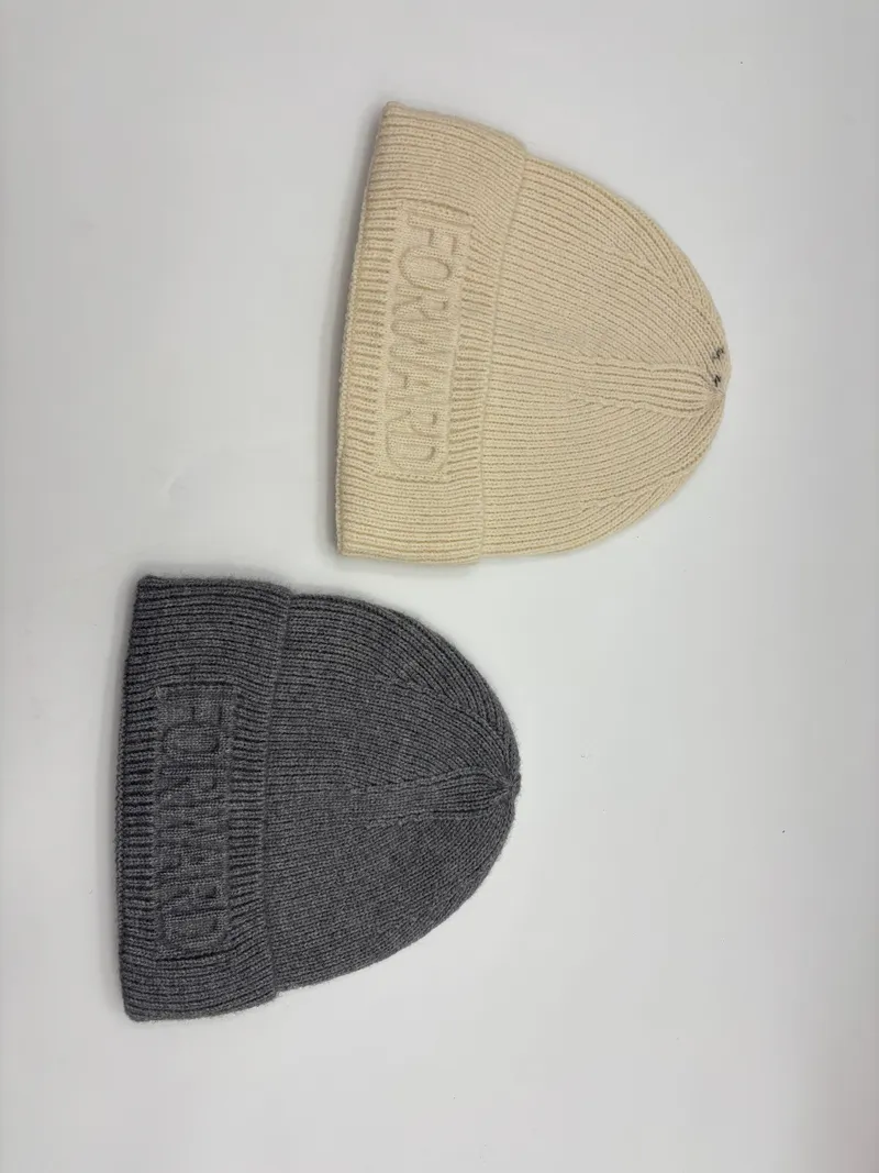 Zwei Rippenstrickmützen in Creme und Grau mit ton-in-ton geprägtem Forward-Logo am Umschlagbündchen, flach auf weißem Untergrund