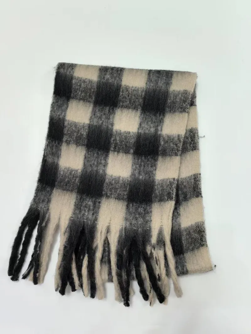 Großkarierter Winterschal in Schwarz-Weiß im Buffalo-Check-Design mit Fransenenden, gefaltet auf weißem Hintergrund