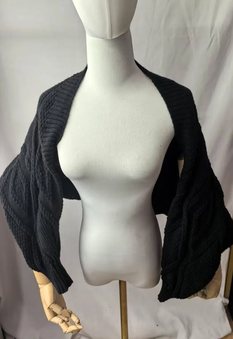 Schwarzer grob gestrickter Bolero-Shrug mit breiten Fledermausärmeln auf einer Schneiderpuppe
