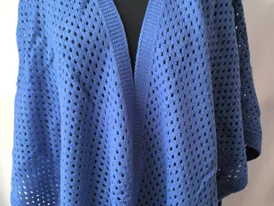 Blauer Offenstrick-Cocoon-Cardigan mit Lochstrickdetails auf Schneiderpuppe, mit breiten Ärmeln und geöffneter Vorderseite