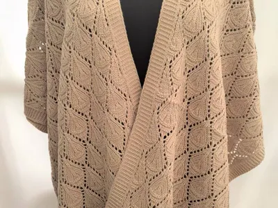 Übergroßer cremefarbener Strickjacke mit offenem Vorderausschnitt und quadratischem Blattmuster in Häkeloptik auf einer Schneiderpuppe