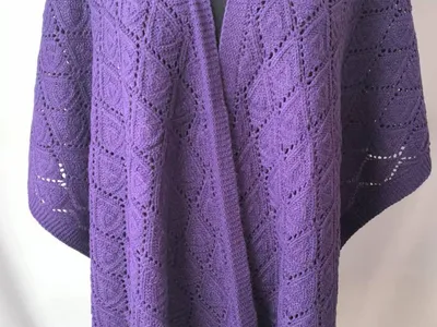 Violette Strick-Wickelstola mit offenem Vorderausschnitt und elegantem Rautenreliefmuster auf einer Schneiderpuppe in voller Länge