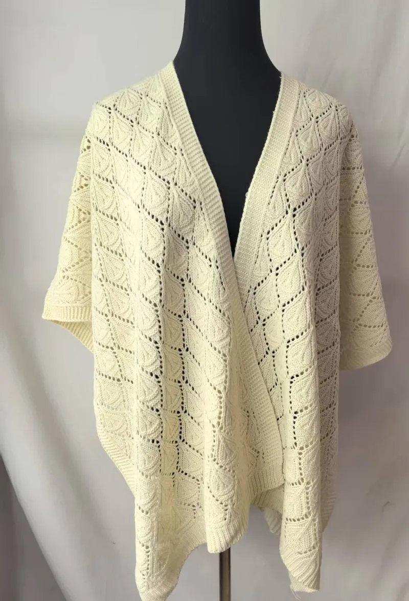 Elfenbeinfarbener Strickponcho mit offenem Rautenmuster und Blatt-Stichdetails auf schwarzer Schneiderpuppe