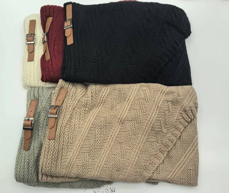 Fünf gefaltete Kuscheldecken aus Grobstrick in Beige, Grau, Schwarz, Burgund und Creme mit braunen Leder-Schnallenriemen