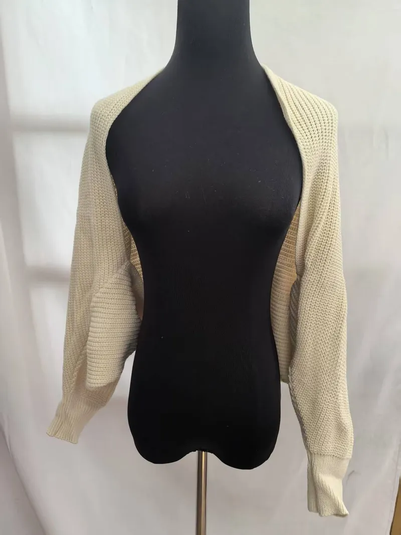 Cremefarbener Kurzstrick-Bolero Shrug mit langen Ärmeln und Rippbündchen auf schwarzer Kleiderpuppe
