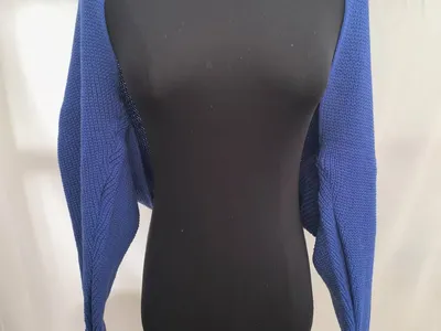 Royalblaue Kurzstrickjacke mit Grobmuster und langen Ärmeln auf schwarzer Kleiderpuppe