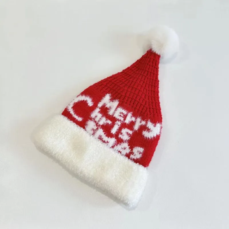Gestrickte Weihnachtsmütze in Rot mit eingestricktem Schriftzug Merry Christmas, weißem Fellbündchen und Pompom-Spitze