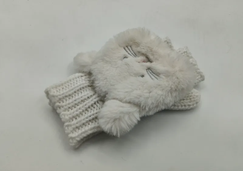 Paar weißer Fingerlos-Handschuhe aus Kunstfell mit aufgesticktem Katzengesicht und breitem, grobgestricktem Rippenbündchen auf weißem Hintergrund