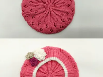Rosa gestrickte Baskenmütze mit Lochstrickmuster, weißem Rippenbündchen und drei Häkelblumen-Applikationen in Rosa, Weiß und Beige