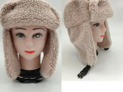 Cremefarbene Sherpa-Fleece-Uschanka-Trappermütze mit klappbaren Ohrklappen und verstellbarem Kinnriemen auf Schaufensterkopf, Vorder- und Seitenansicht