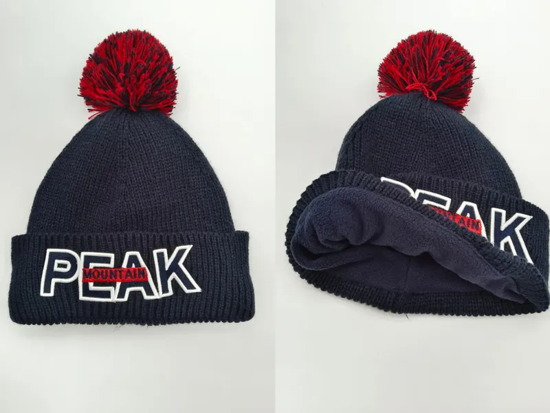 Navyblaue Rippenstrickmütze mit rotem Bommel und gesticktem PEAK MOUNTAIN Schriftzug auf umgeklapptem Bündchen, Vorder- und Innenansicht