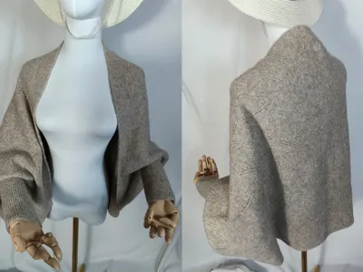 Vorder- und Rückenansicht einer taupefarbenen Spitzenstrick-Shrug-Jacke mit Ballonärmeln und Rippbündchen auf einer Schneiderpuppe