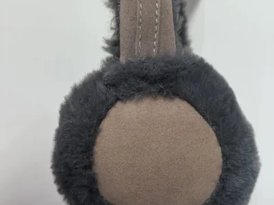 Blaue flauschige Plüsch-Ohrenschützer in Form eines niedlichen Tierkopfes mit roten Pompom-Fühlern und cremefarbenen Akzenten auf weißem Hintergrund