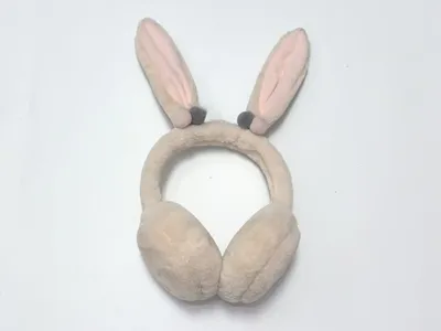 Beige flauschige Kunstfell-Ohrenschützer mit weichem Stirnband auf weißem Hintergrund, gemütliche Winterohrenmuscheln