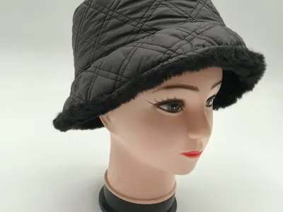 Dunkelgraue Steppkappe im Bucket-Hat-Stil mit schwarzem Kunstfellbesatz am Krempenrand auf weiblichem Modellkopf in Produktfoto-Aufnahme