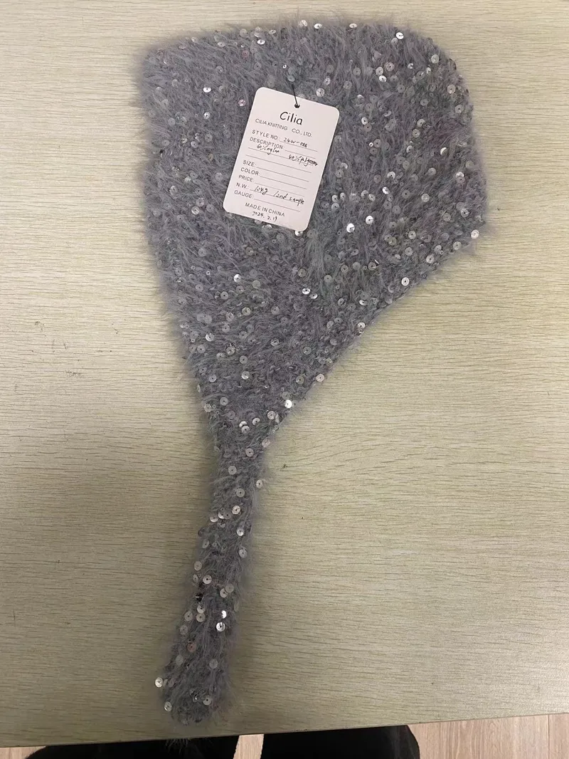 Schwarze Ohrenwärmer mit flauschigen Ohrmuscheln und gestricktem Bügel mit weißer Aufschrift und rotem Streifenmuster, weißer Hintergrund