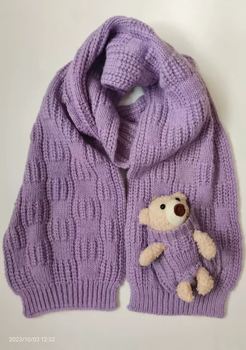 Lavendelfarbener Grobstrick-Cardigan in Übergröße mit breitem Schalkragen und kleinem Teddybär-Plüschtier in der Brusttasche, Flachlayansicht
