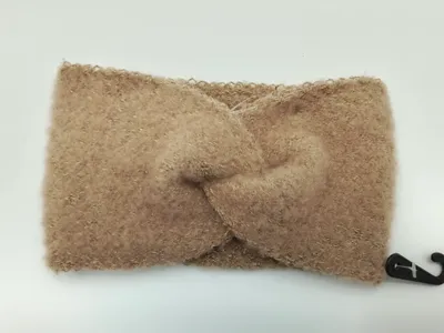 Weiches kamelienfarbenes Flausch-Stirband mit elegantem Twistknoten-Detail und dezent eingearbeiteten goldenen Metallfäden, flach fotografiert