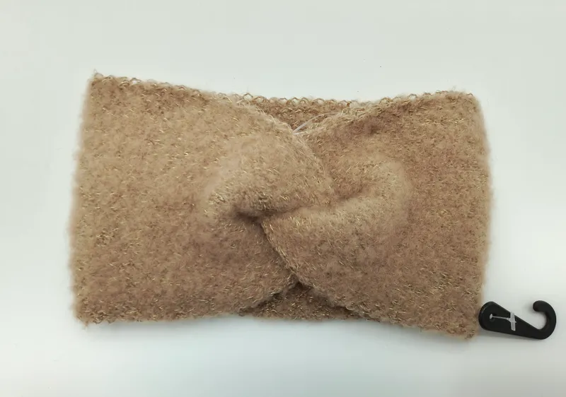 Weiches kamelienfarbenes Flausch-Stirband mit elegantem Twistknoten-Detail und dezent eingearbeiteten goldenen Metallfäden, flach fotografiert
