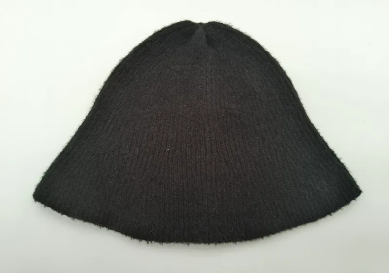 Dunkel anthrazitfarbene Rippenstrickmütze aus Wollmisch flach liegend, mit sichtbarer Rippenstruktur auf weißem Hintergrund