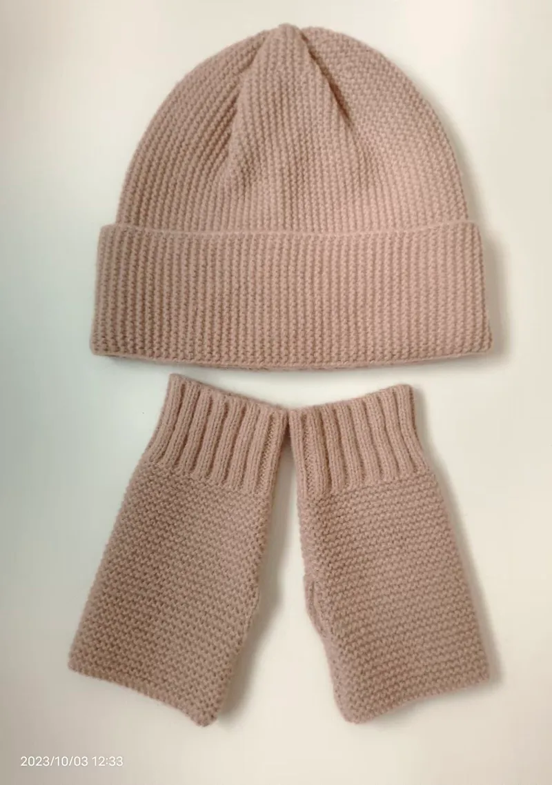 Puderfarbenes Grobstrick-Set aus Beanie-Mütze und passenden fingerlosen Handschuhen, flach auf weißem Hintergrund
