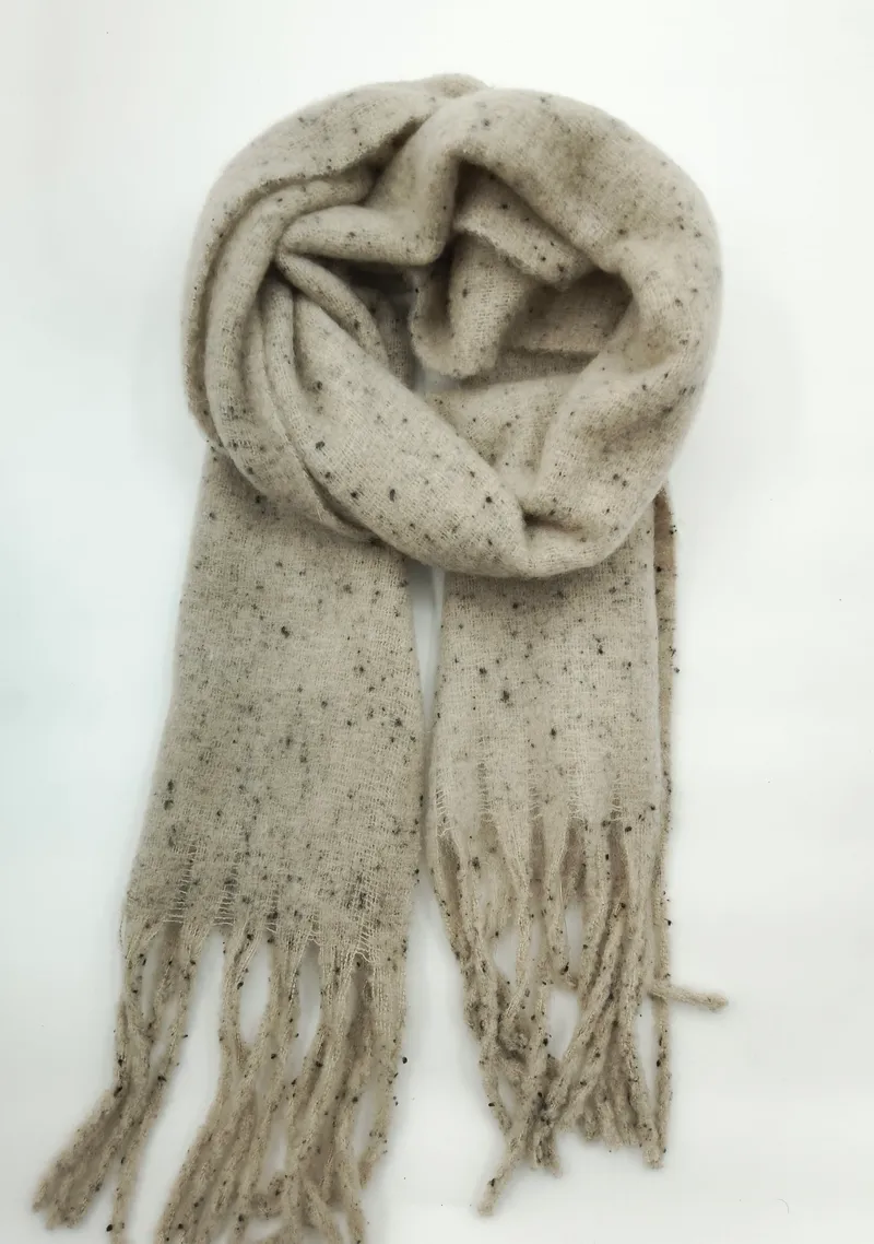 Cremefarbener Schal mit dunklen Sprenkeln aus weichem Strickgarn, locker gerollt mit Fransenzipfeln auf weißem Hintergrund