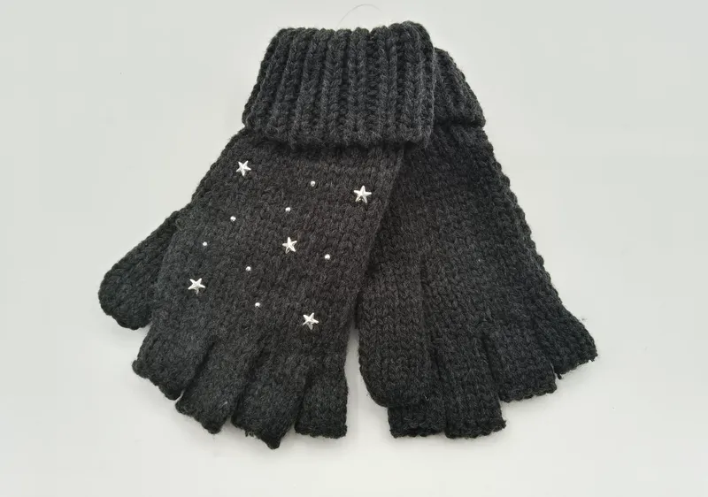Anthrazitfarbene fingerlose Stulpenhandschuhe aus Grobstrick mit aufgenähten silbernen Sternnieten und Kristallverzierungen auf weißem Hintergrund