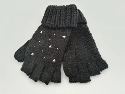 Anthrazitfarbene fingerlose Stulpenhandschuhe aus Grobstrick mit aufgenähten silbernen Sternnieten und Kristallverzierungen auf weißem Hintergrund