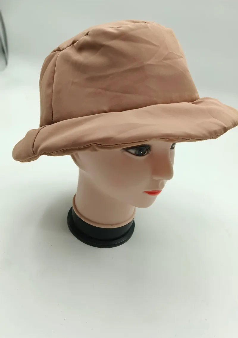 Beigefarbene wattierte Nylon-Bucket-Hat auf Hutständer, mit breiter Krempe und charakteristischer Steppnähten an der Außenseite
