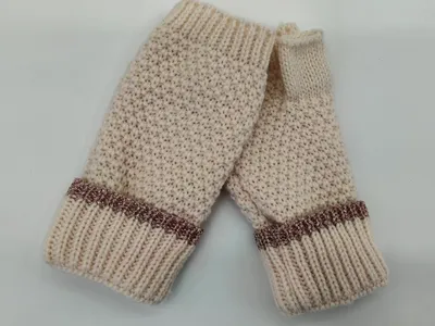 Paar cremefarbene Grobstrick-Handschuhe ohne Finger mit gerippten Manschetten und roségoldenem Glanzband als Abschluss