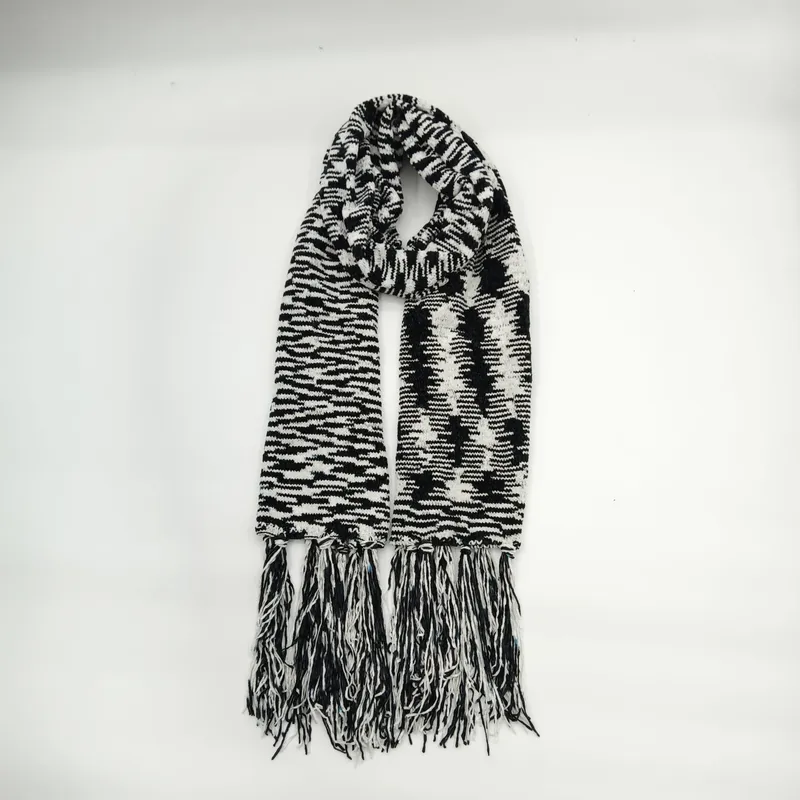 Schwarz-weißer Strickschal im klassischen Hahnentritt-Muster mit langen gemischten Fransenquasten, gefaltet auf weißem Hintergrund präsentiert