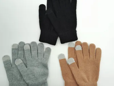 Drei Paar gestrickte Winterhandschuhe mit Touchscreen-Funktion in den Farben Anthrazit, Hellgrau und Sandbeige, ordentlich nebeneinander auf weißer Fläche