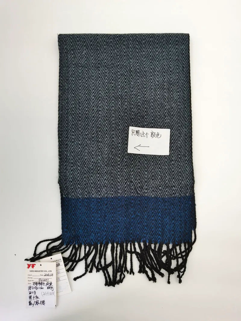 Grau-blauer Webschal mit Fischgrätmuster und zweifarbigem Farbblock-Design sowie schwarzem Fransensaum, flach auf weißem Untergrund fotografiert
