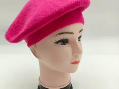 Pinkes Wollbarett mit rundem Schnitt und Zierknopf auf Mannequin-Kopf, Seitenansicht