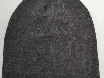 Dunkelgrauer Feinstrick-Slouchy-Beanie flach auf weißem Untergrund, unisex Wintermütze
