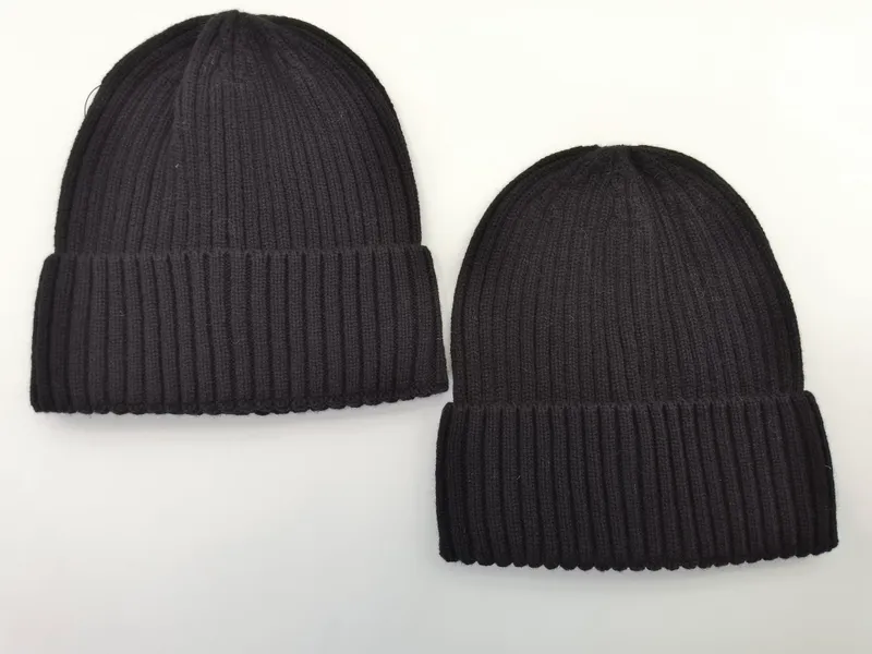 Zwei Rippenstrick-Beanies nebeneinander, einer in Dunkelgrau und einer in Schwarz, beide mit gefaltetem Umschlag auf weißem Hintergrund
